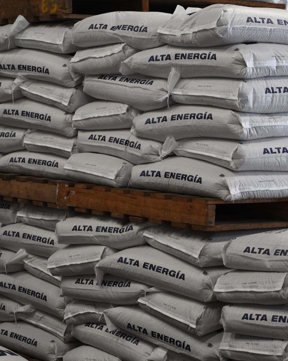 Sacos de alimento Alta Energía apilados sobre palés en el almacén